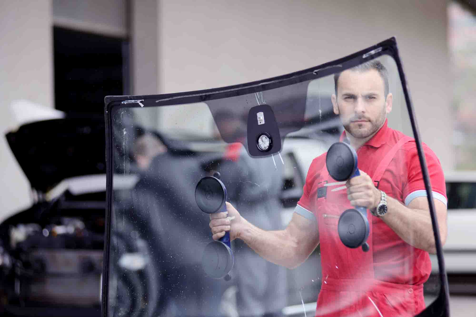 Tech Carrying windshield to replace auto glass - advanced auto solutions collision repair services 